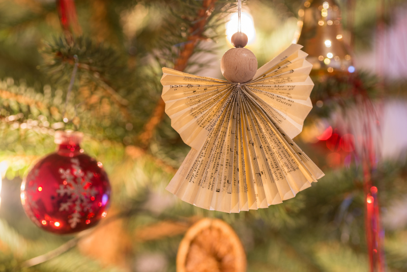 Selbst gebastelter Weihnachtsengel aus Holz und Papier am Weihnachtsbaum.